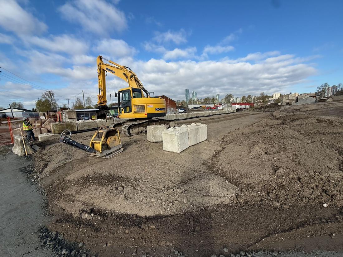 Excavator working a site under a blue sky